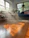 A happy customer smiling in a freshly cleaned living room with sunlight streaming through the windows.