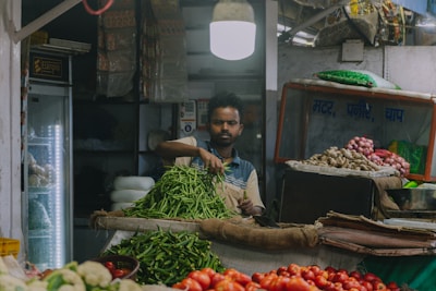 Photo of a street vendor arranging fresh vegetables at a bustling market in India.