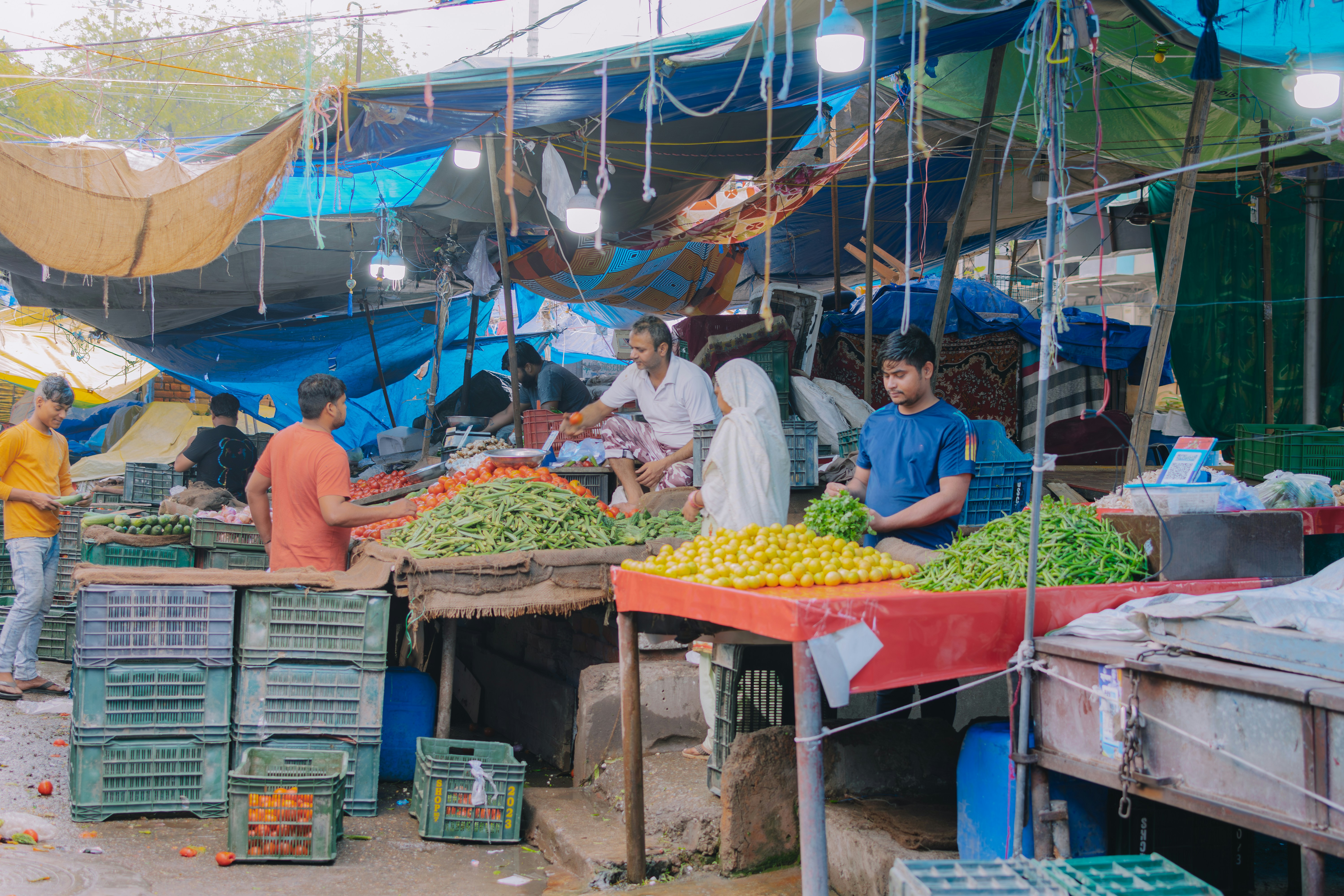 a group of people standing around a fruit and vegetable market