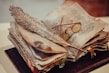 Close-up of an open ancient manuscript with handwritten notes and a vintage quill pen.