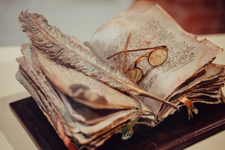 An antique quill pen resting on an old, weathered book, with eerie candlelight illuminating the pages.