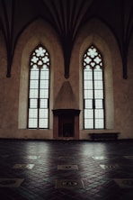 a room with two large windows and a tiled floor