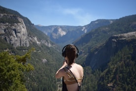 A person enjoying music on headphones while driving through a scenic route.