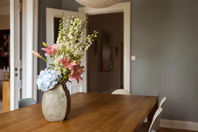 Minimalist dining table centerpiece featuring delicate silk flowers in soft pastels.