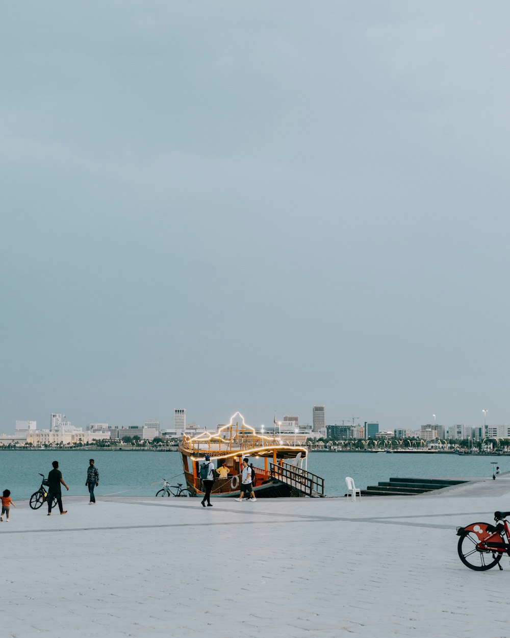 a group of people walking on a beach next to a boat