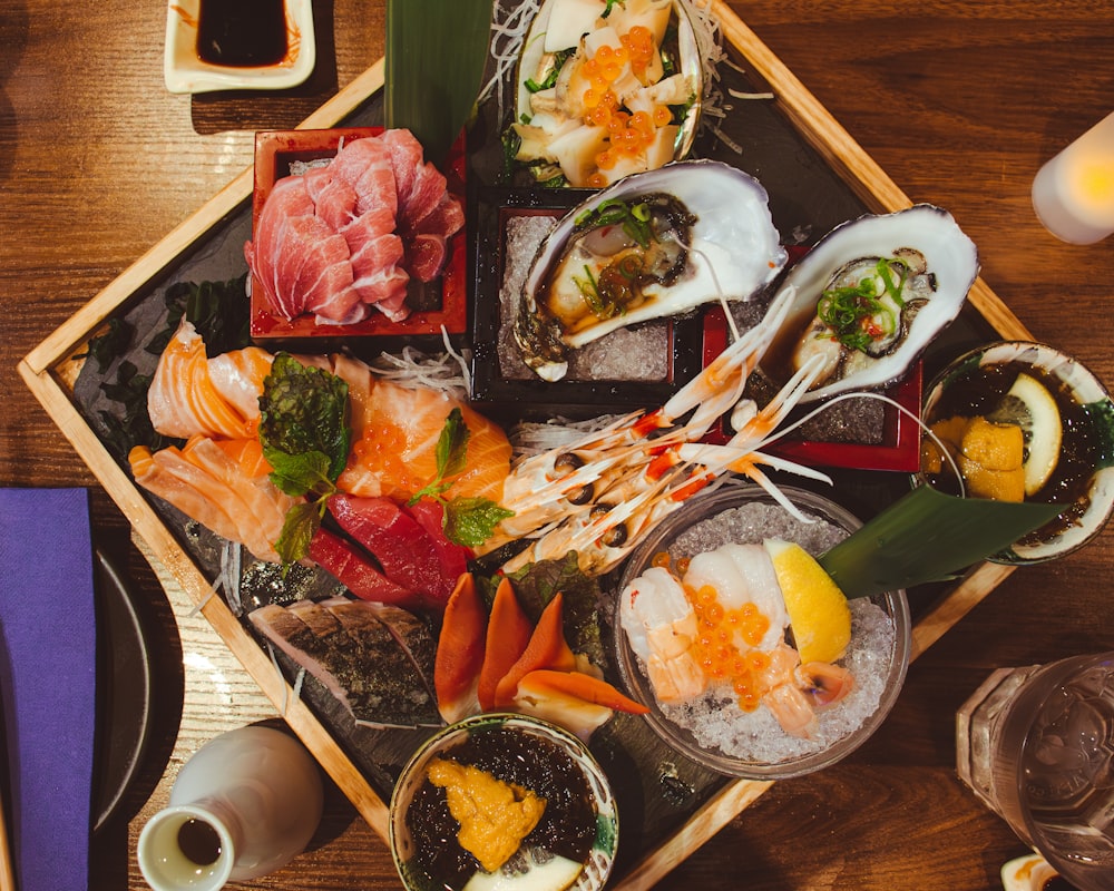 a wooden tray topped with lots of different types of food