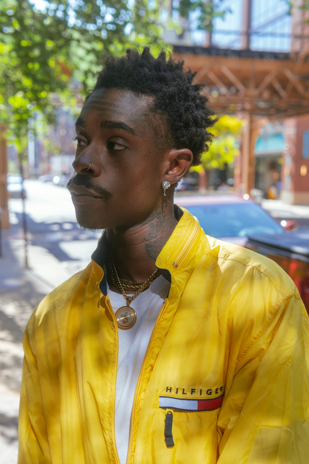 a man in a yellow jacket is standing on the street