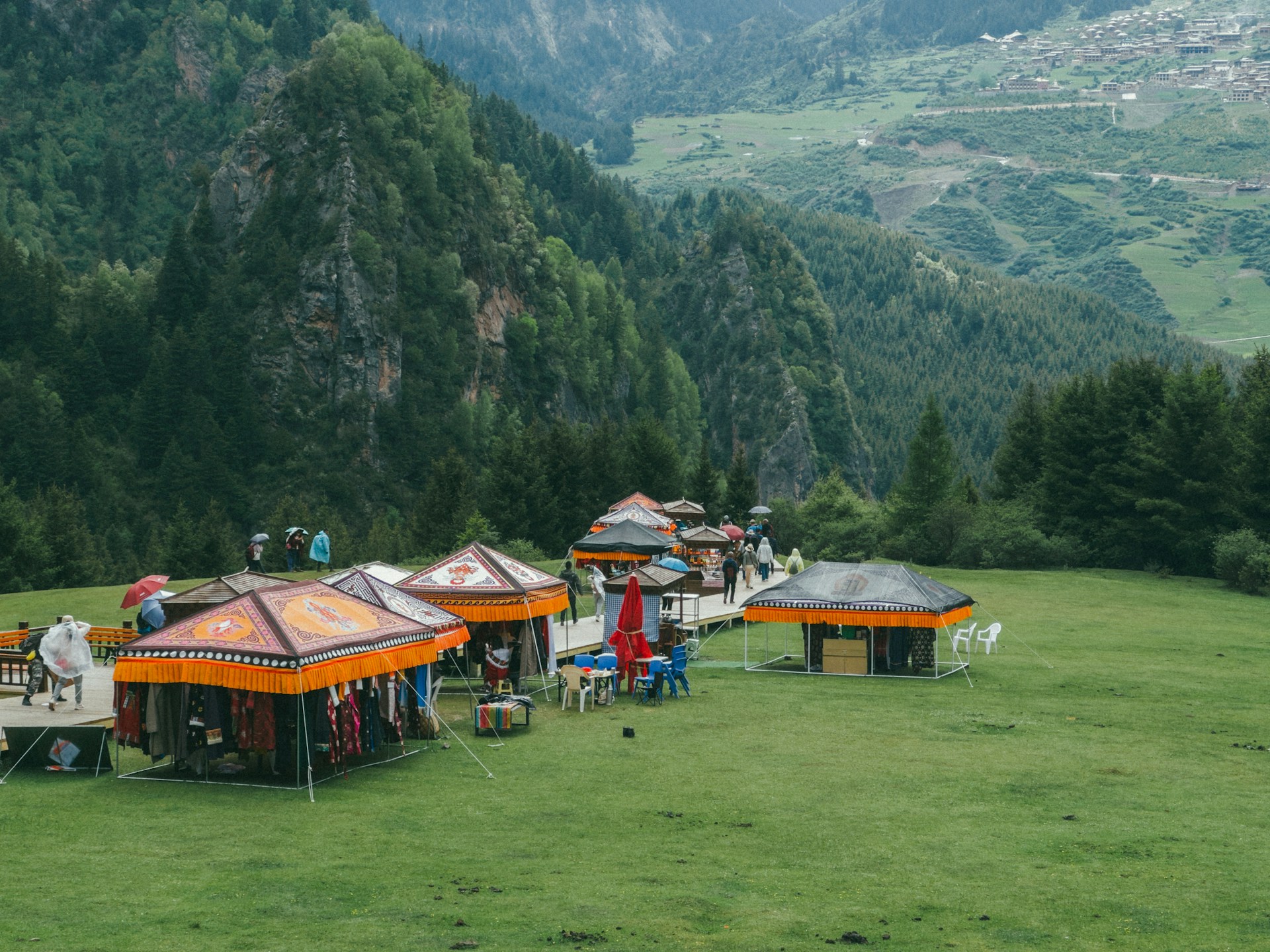 Festival visitors enjoying traditional Arunachal Pradesh cuisine and crafts, surrounded by the natural beauty of Chullyu village.