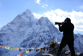 A candid photo of Arif Wazir filming in a mountainous Himalayan village, capturing local life with his camera.