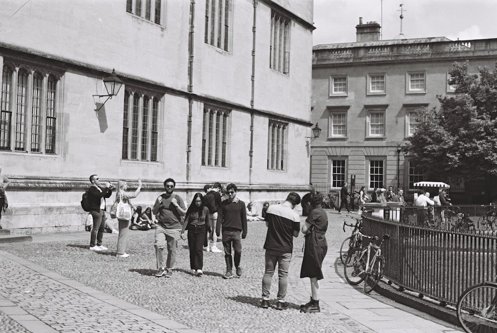 a black and white photo of a group of people standing in front of a building