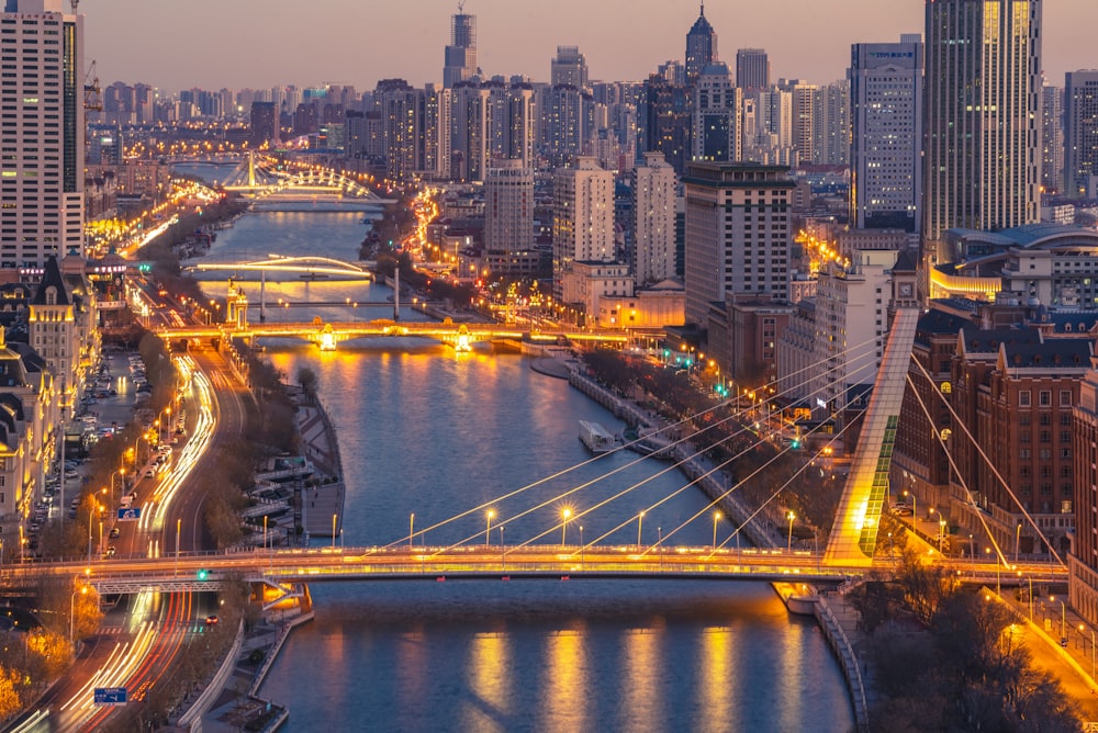 a view of a city at night with a bridge in the foreground