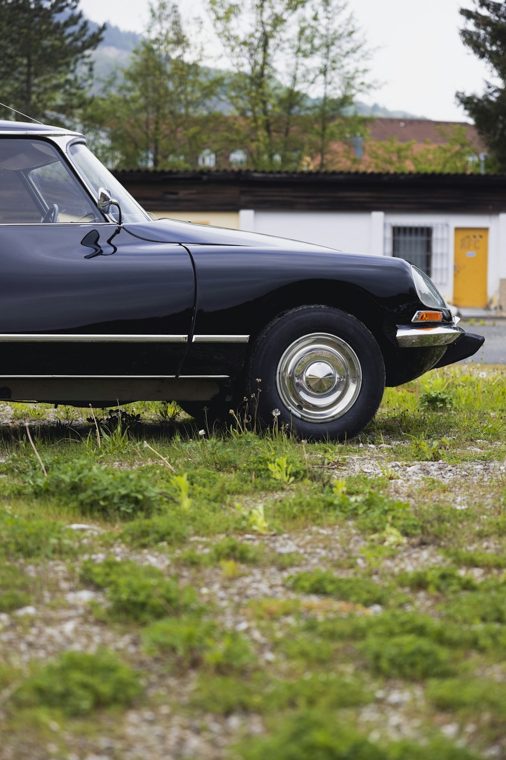 a black car parked in a grassy field