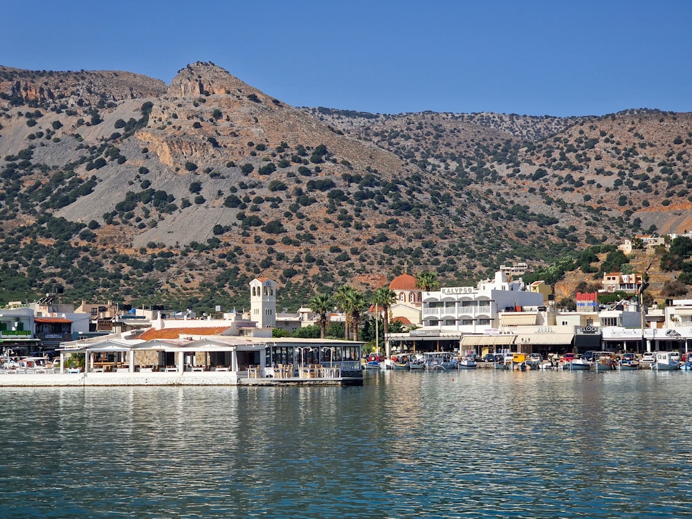 a view of a town on the water with mountains in the background