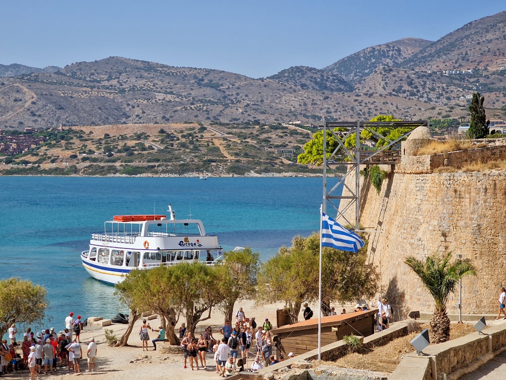 a group of people standing on a beach next to a boat