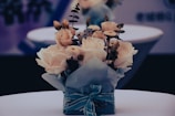 Finished bouquet wrapped in cream paper tied with a soft sage ribbon on a wooden table.