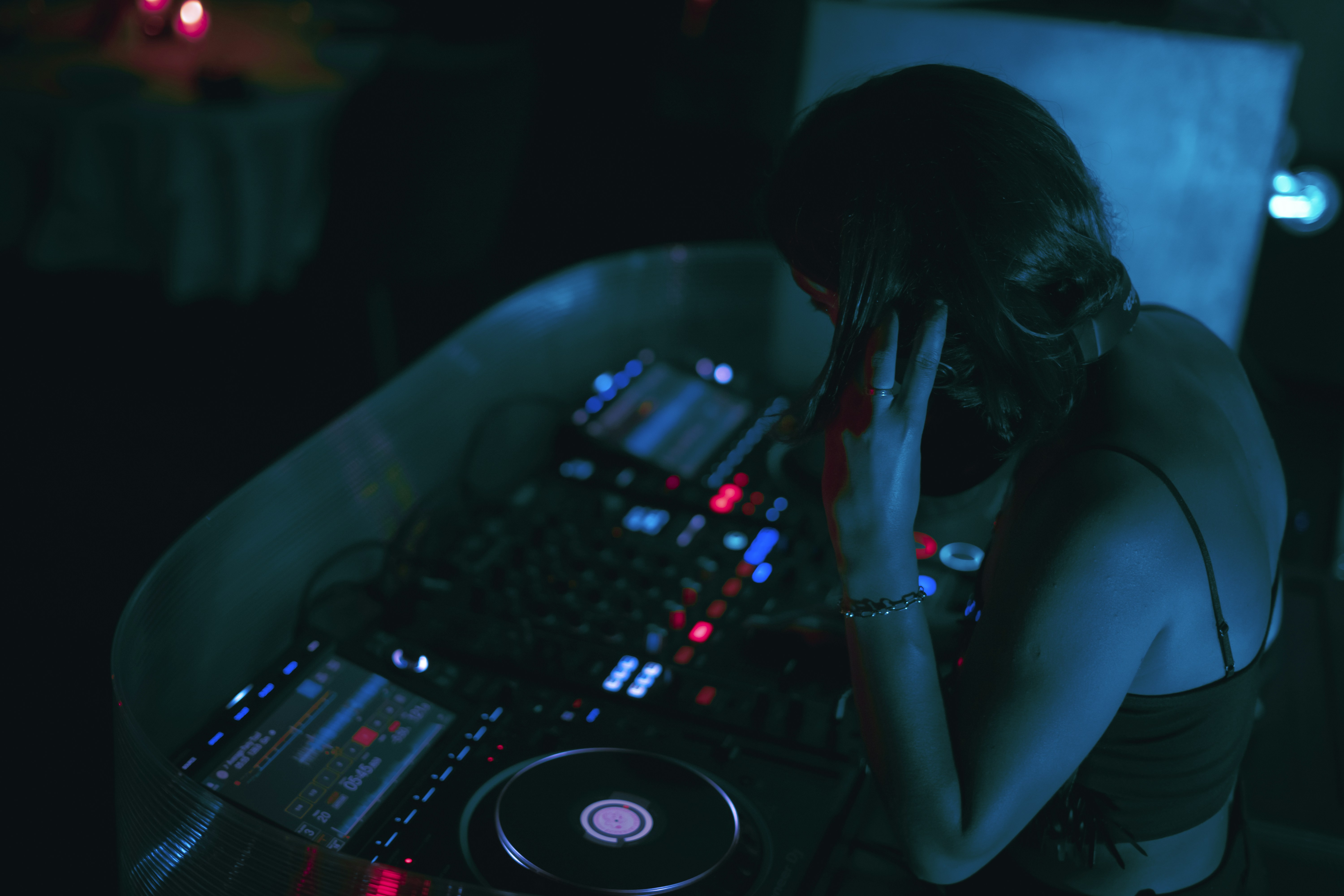 a woman sitting in front of a dj mixer