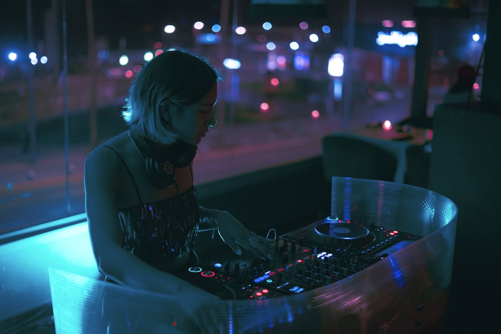 a woman sitting at a table with a dj controller