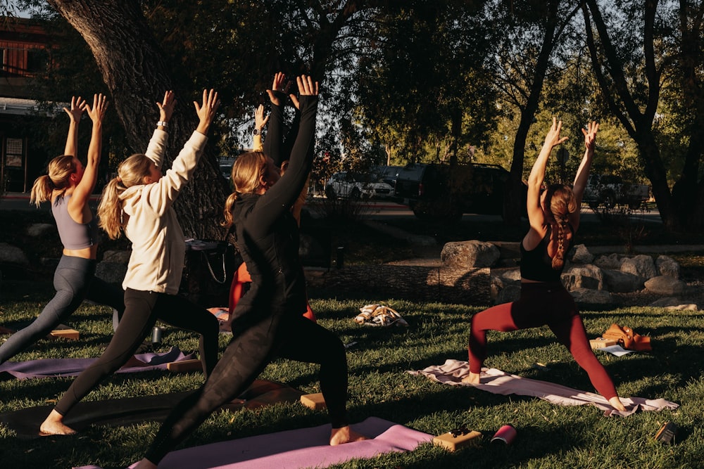 a group of people doing yoga in a park