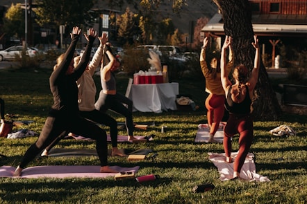 A serene outdoor corporate wellness event with participants doing yoga in the morning light.