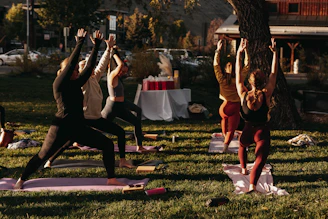 A group of people participating in a yoga session outdoors.