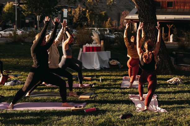 A serene yoga session outdoors at sunrise with soft glowing light.