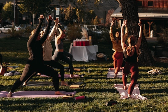 A lively group of older adults enjoying a gentle outdoor yoga session together on a sunny morning.