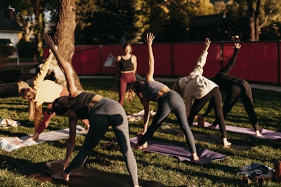 a group of people doing yoga in a park