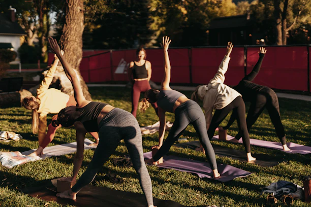 a group of people doing yoga in a park