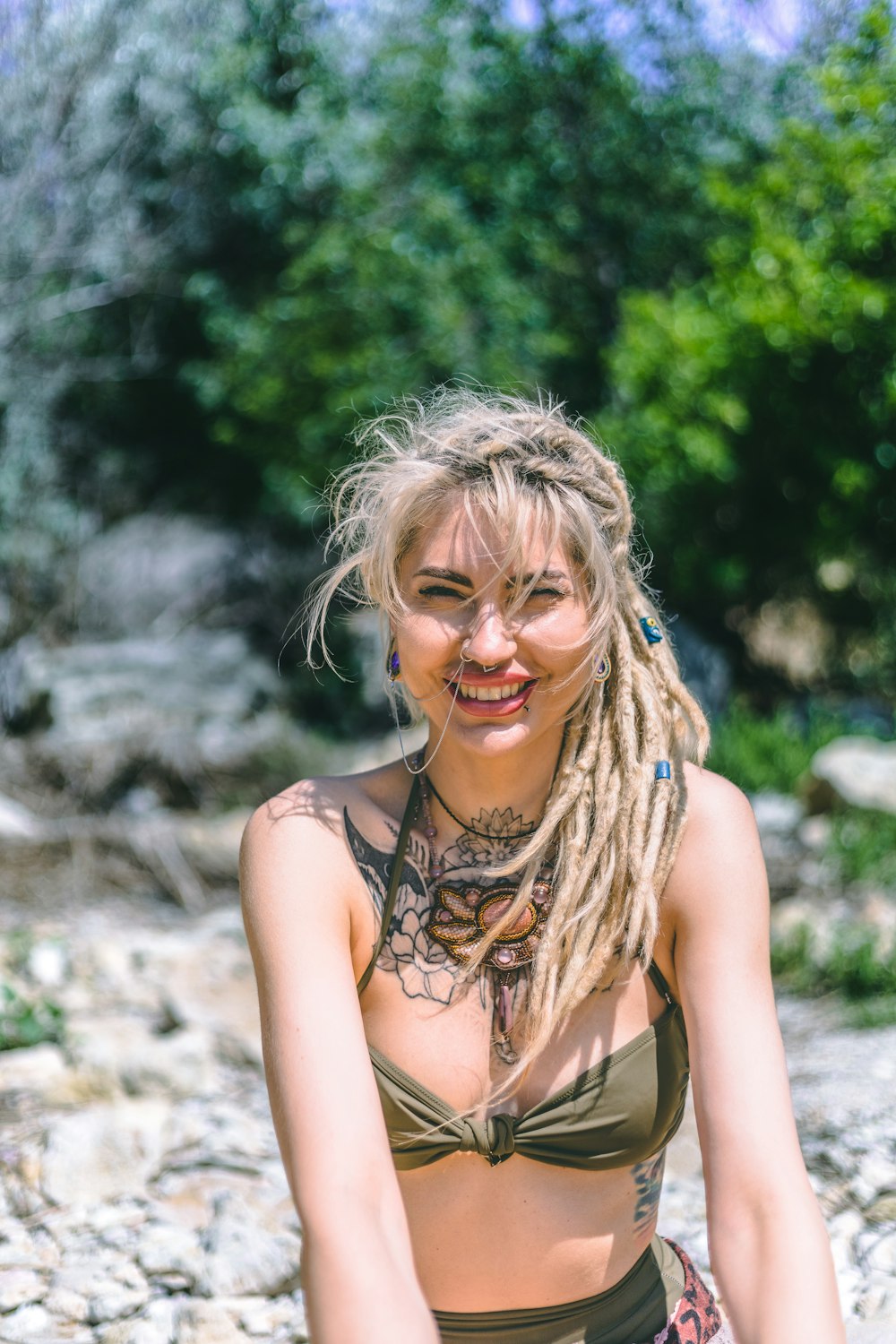 a woman with dreadlocks sitting on a rock