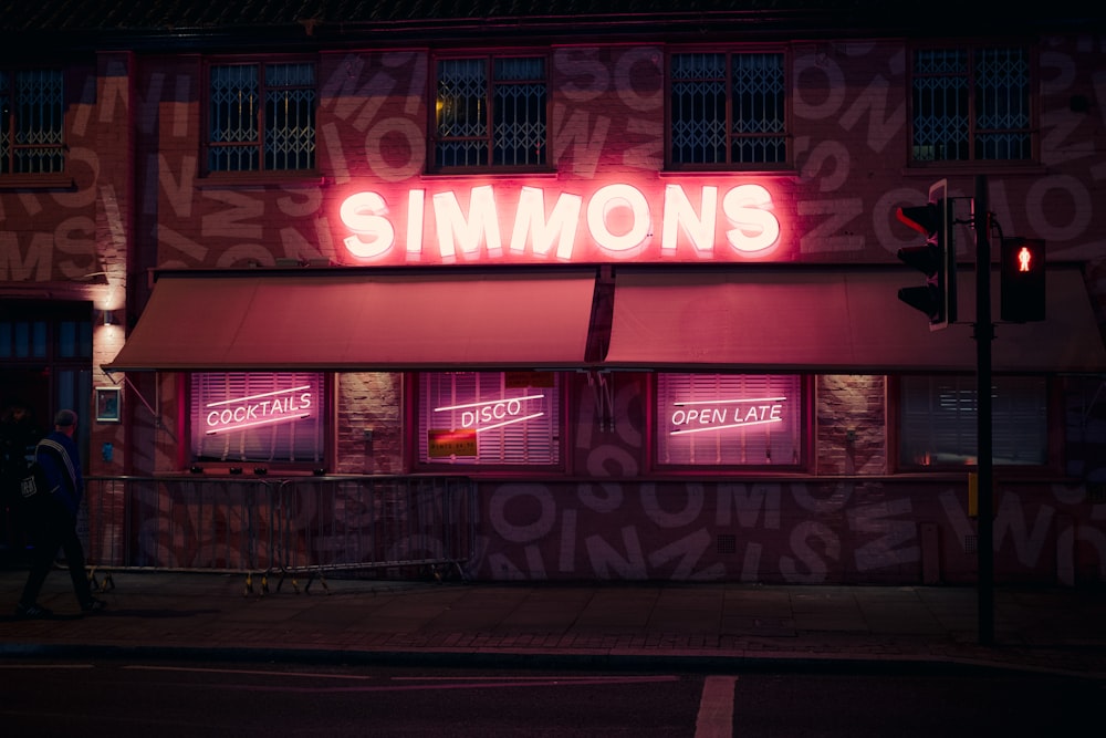 a neon sign that reads simmonss on the side of a building