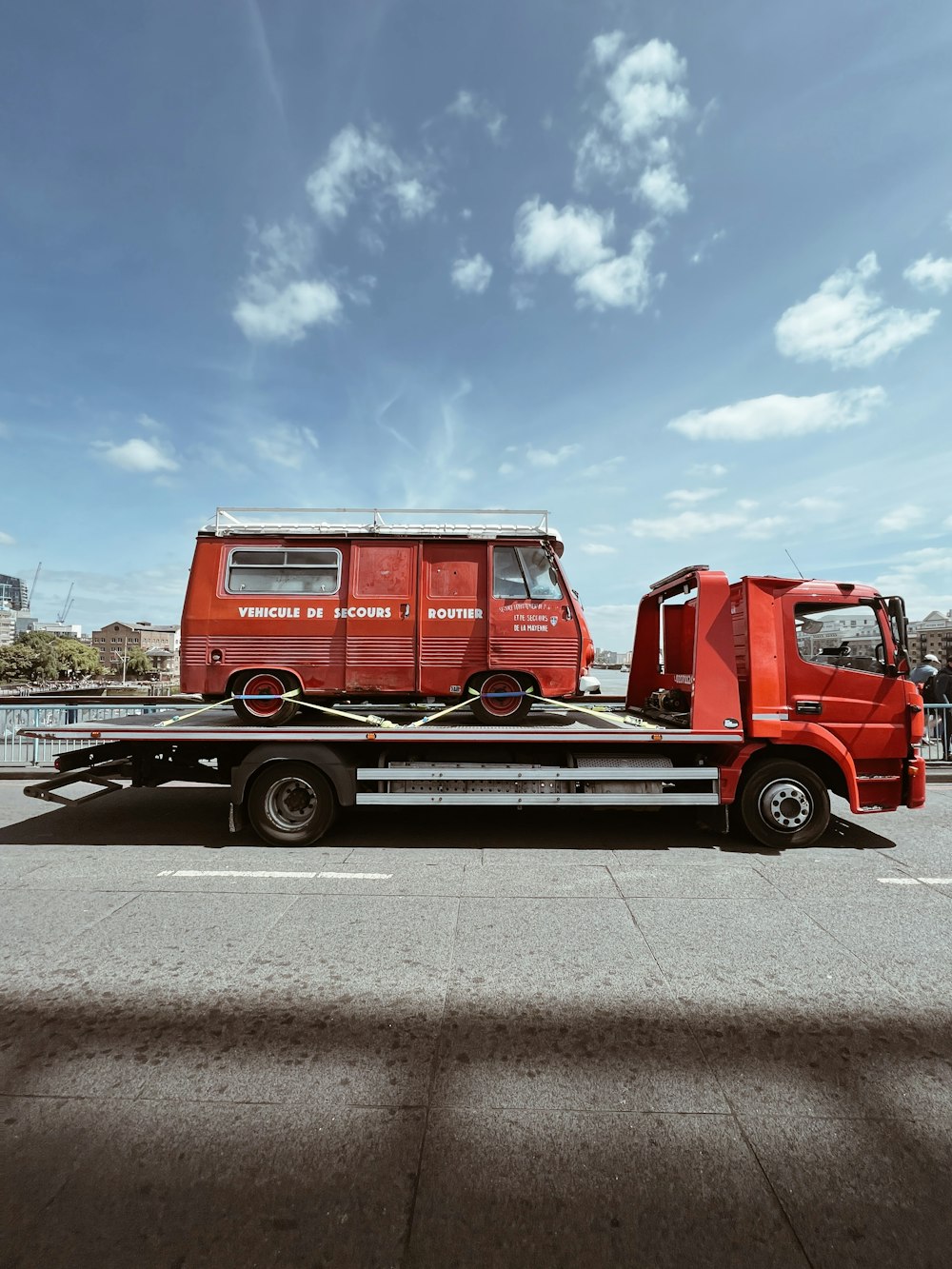 a red truck with a flatbed trailer attached to it