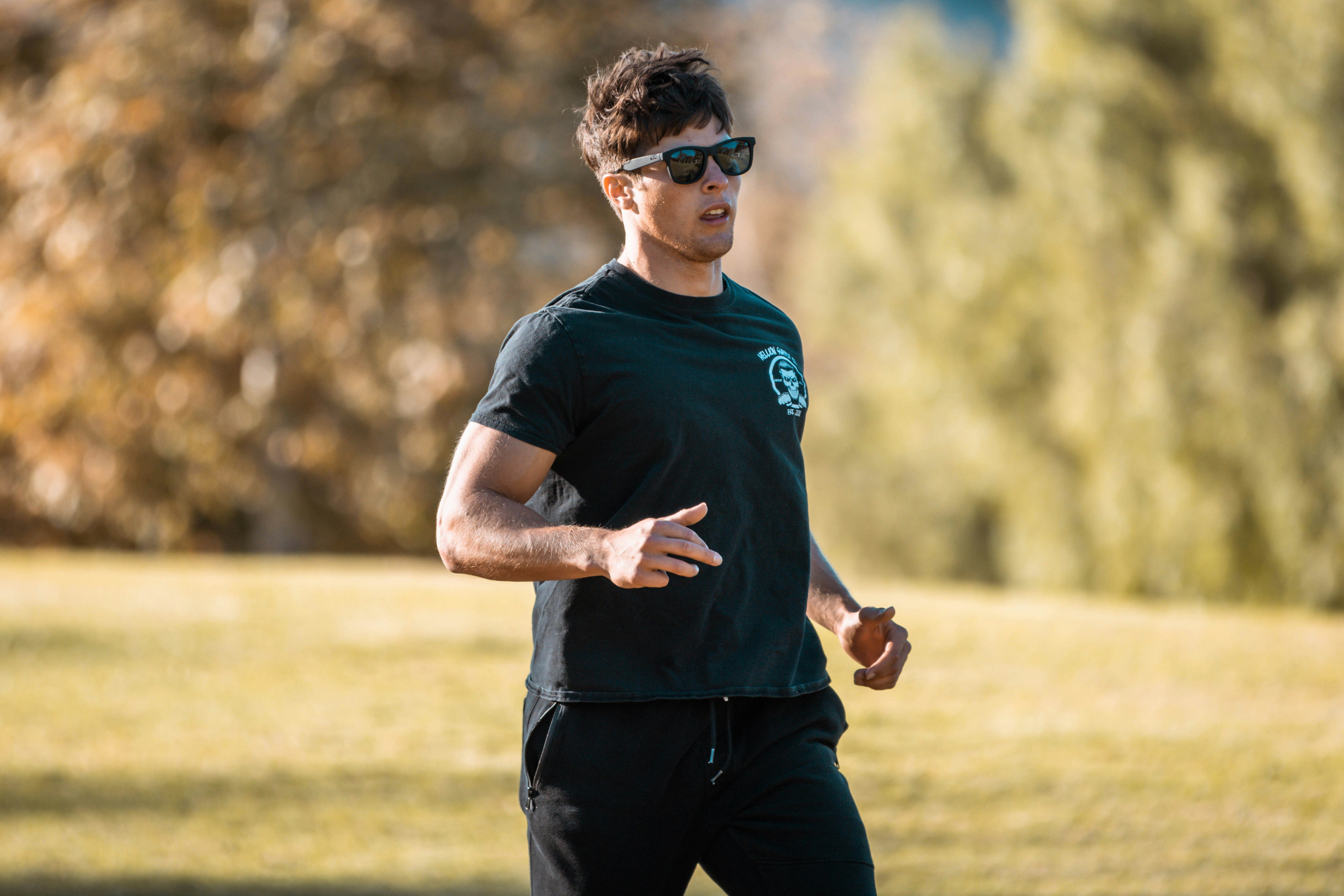 a man in a black shirt is throwing a frisbee