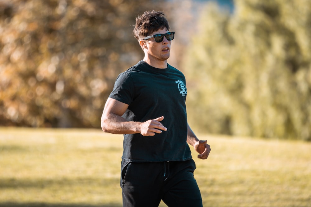 a man in a black shirt is throwing a frisbee