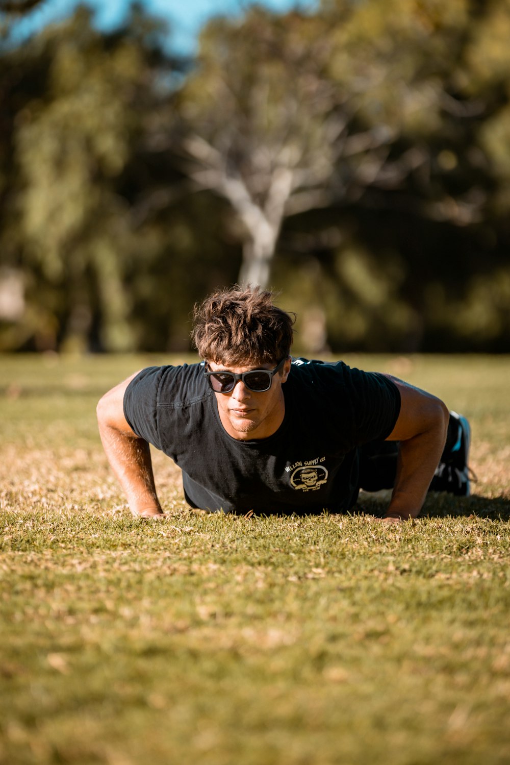 a young man is doing push ups in the grass