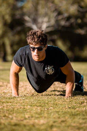 a man is doing push ups in the grass