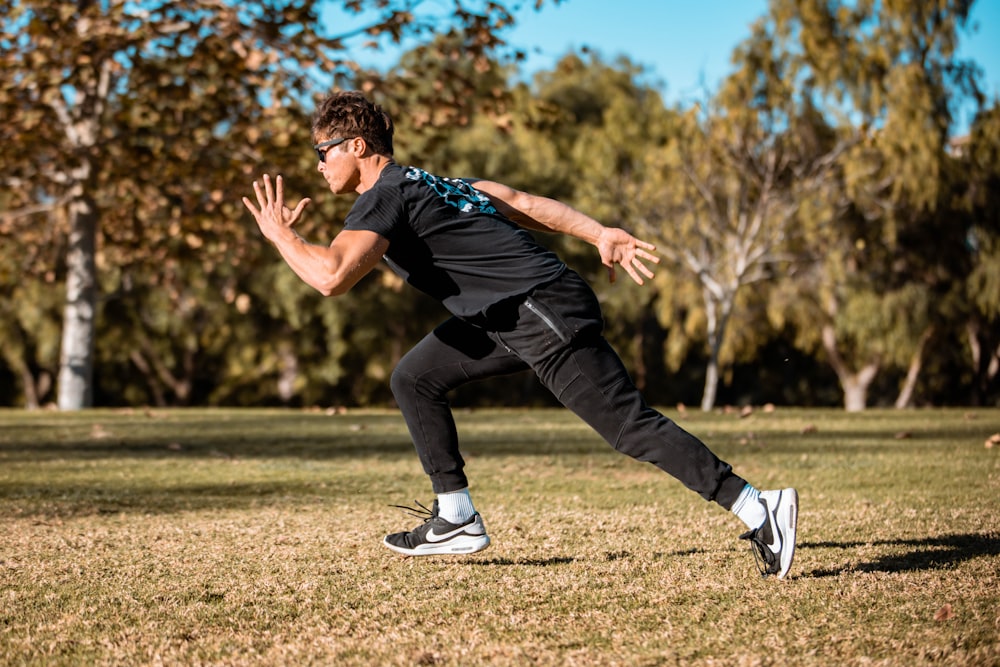 a man in a black shirt is playing frisbee