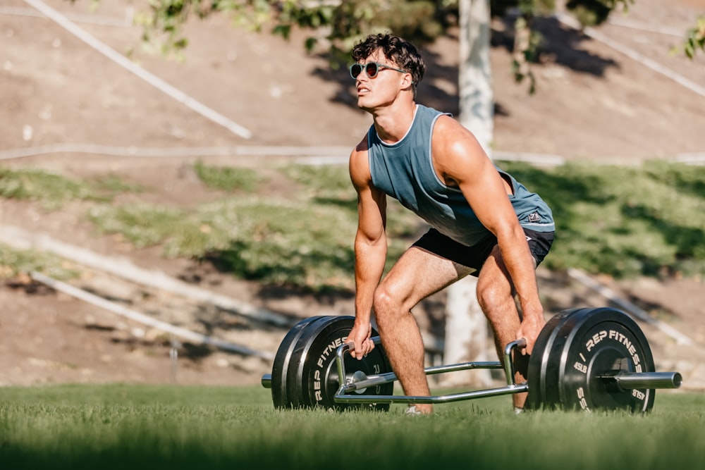 a man is squatting down with a barbell