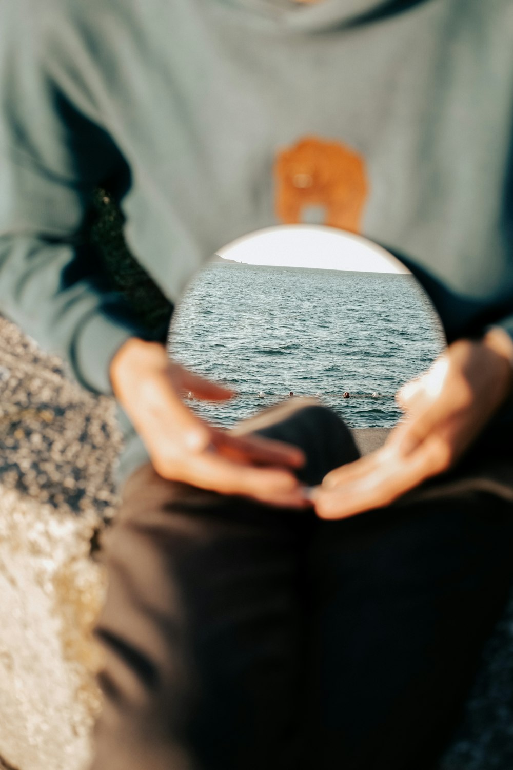 a man sitting on a rock holding a white frisbee