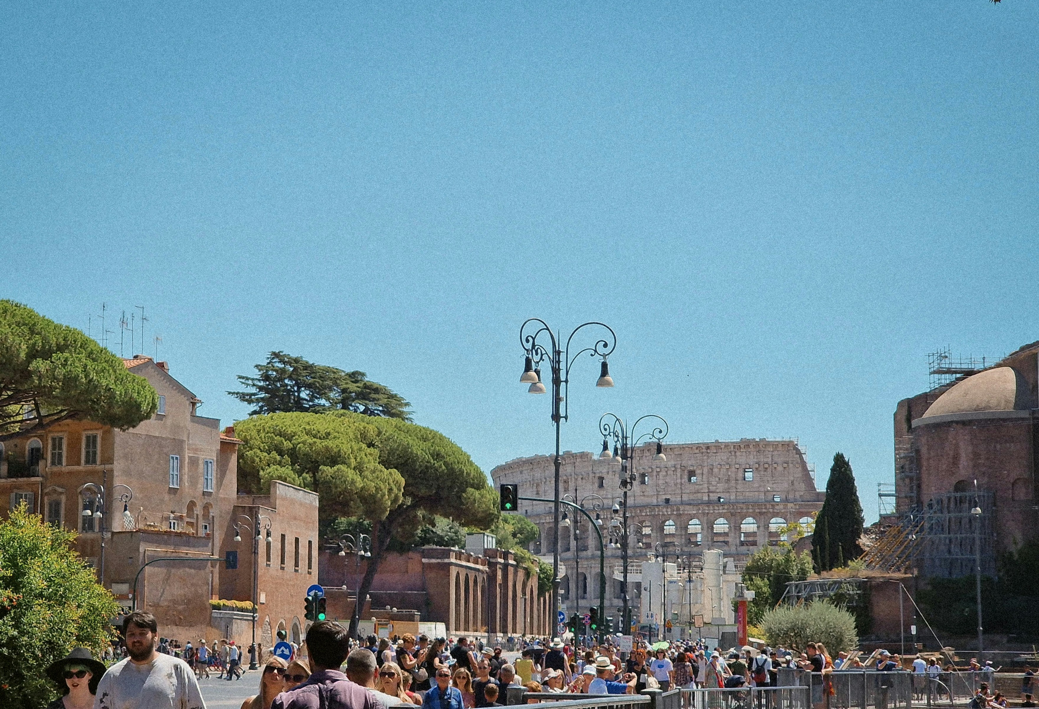 A crowd of people walking down a street next to tall buildings