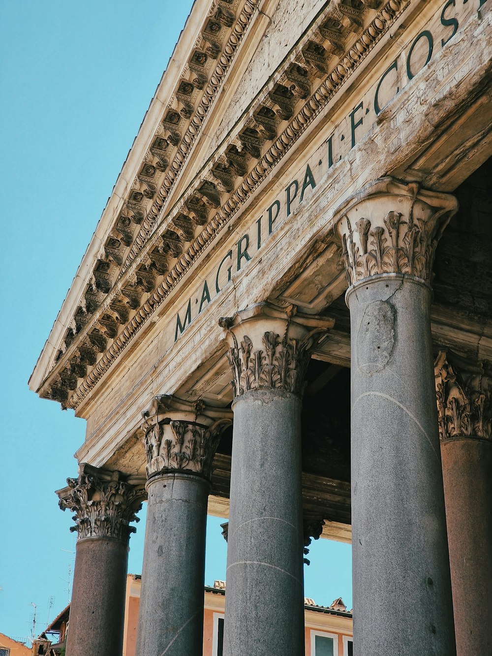 a close up of a building with columns and a sky background