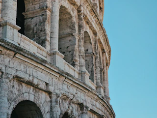Historic architecture of Rome's Colosseum under a clear blue sky.