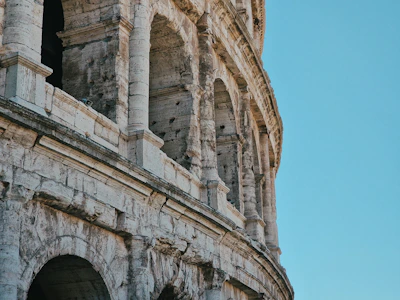 Historic architecture of Rome's Colosseum under a clear blue sky.