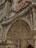 An ornate, intricately detailed stone facade featuring classical architectural elements. The surface is adorned with elaborate carvings, including columns, arches, and detailed relief sculptures depicting historical or religious figures. The craftsmanship displays a high level of artistry with numerous decorative motifs and patterns.