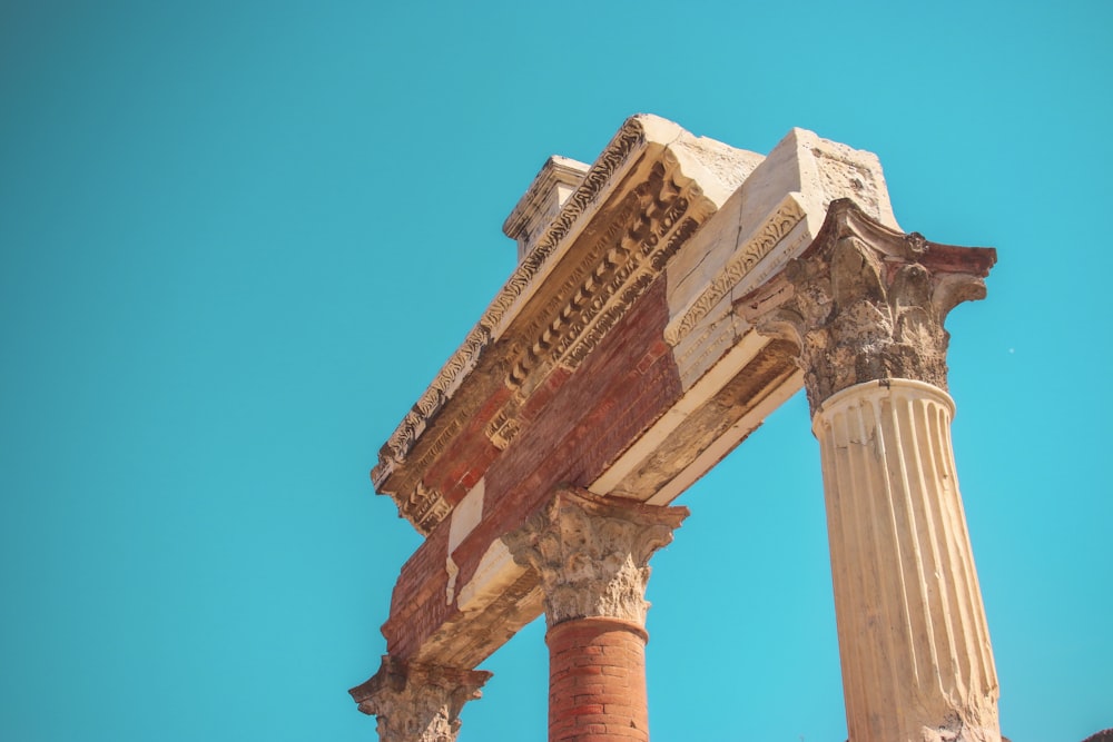 a close up of two columns with a blue sky in the background