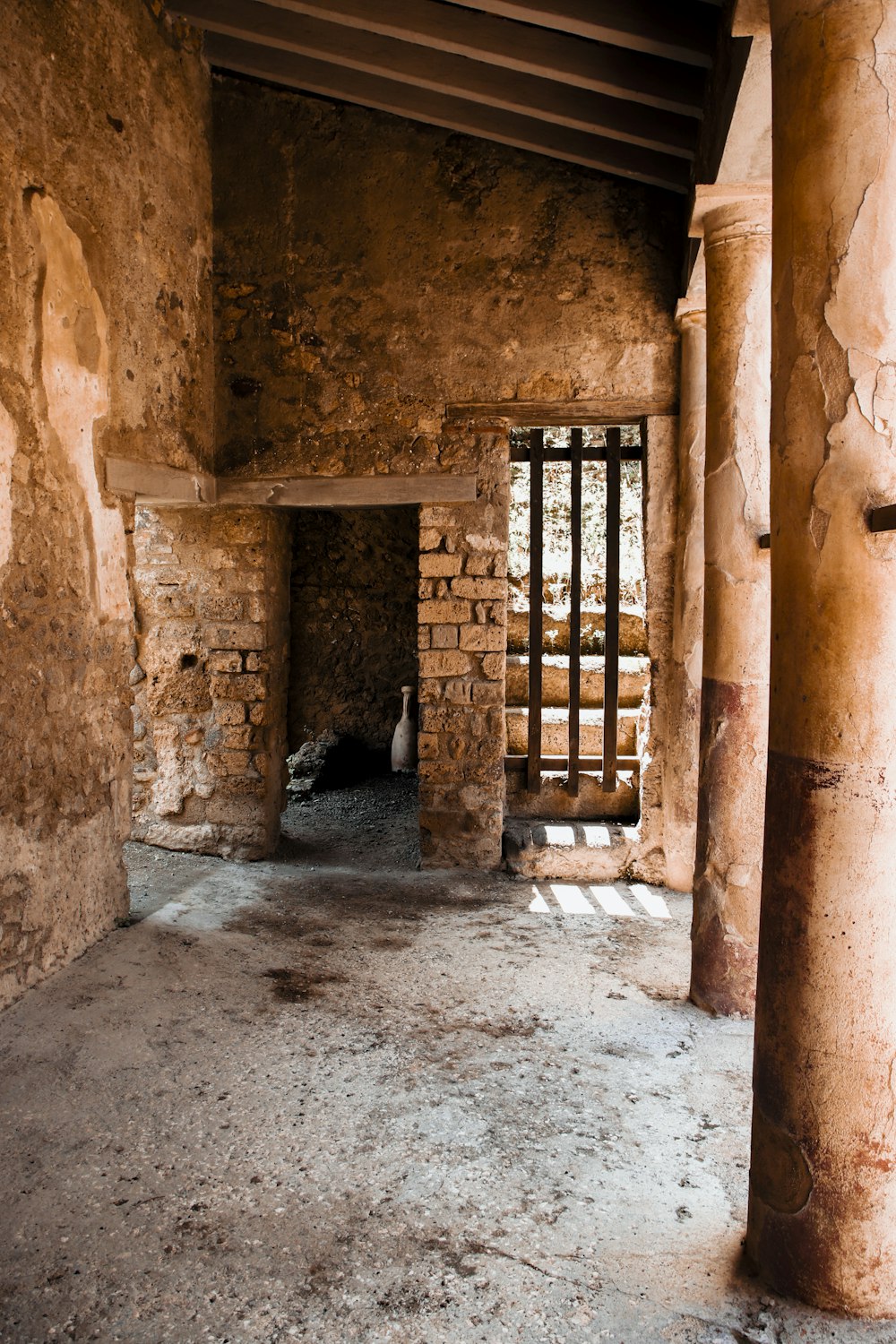 an empty room with a brick wall and a barred window