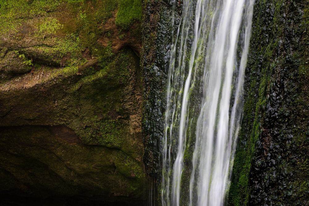 a waterfall with moss growing on the side of it