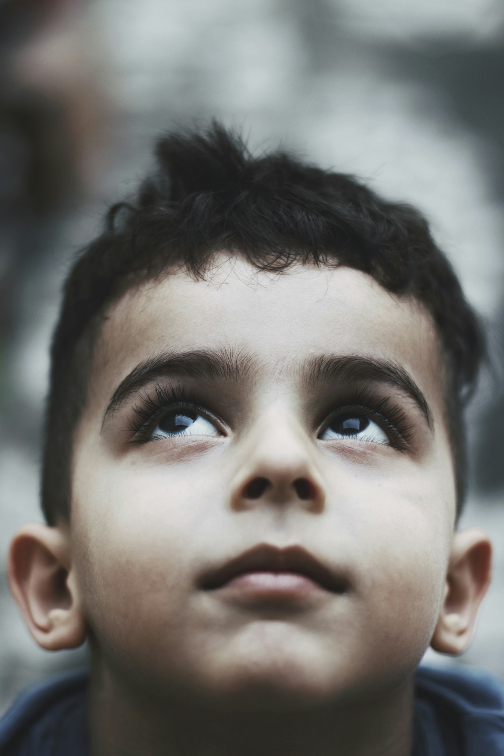 a young boy looking up into the sky