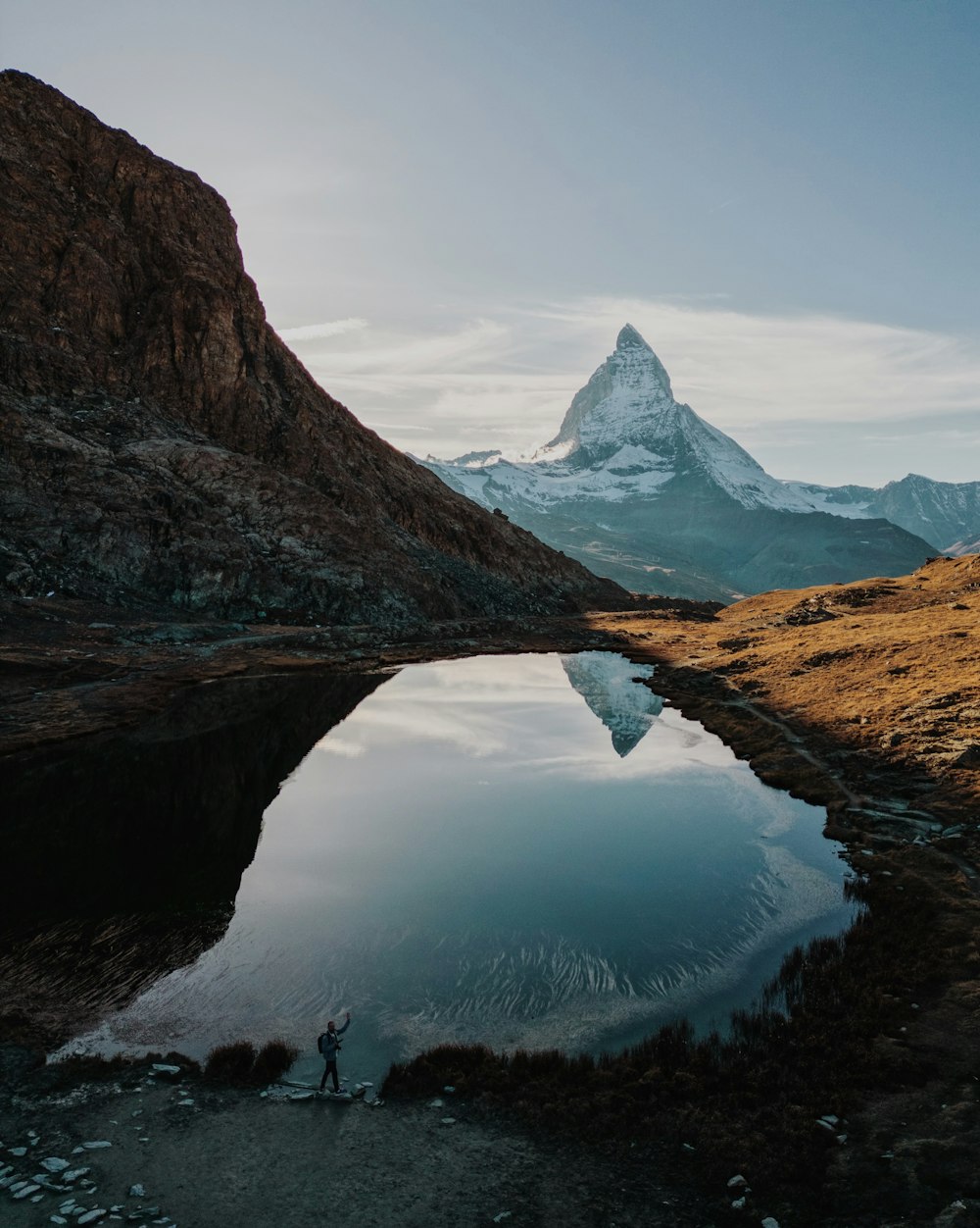 a person standing on a hill next to a body of water