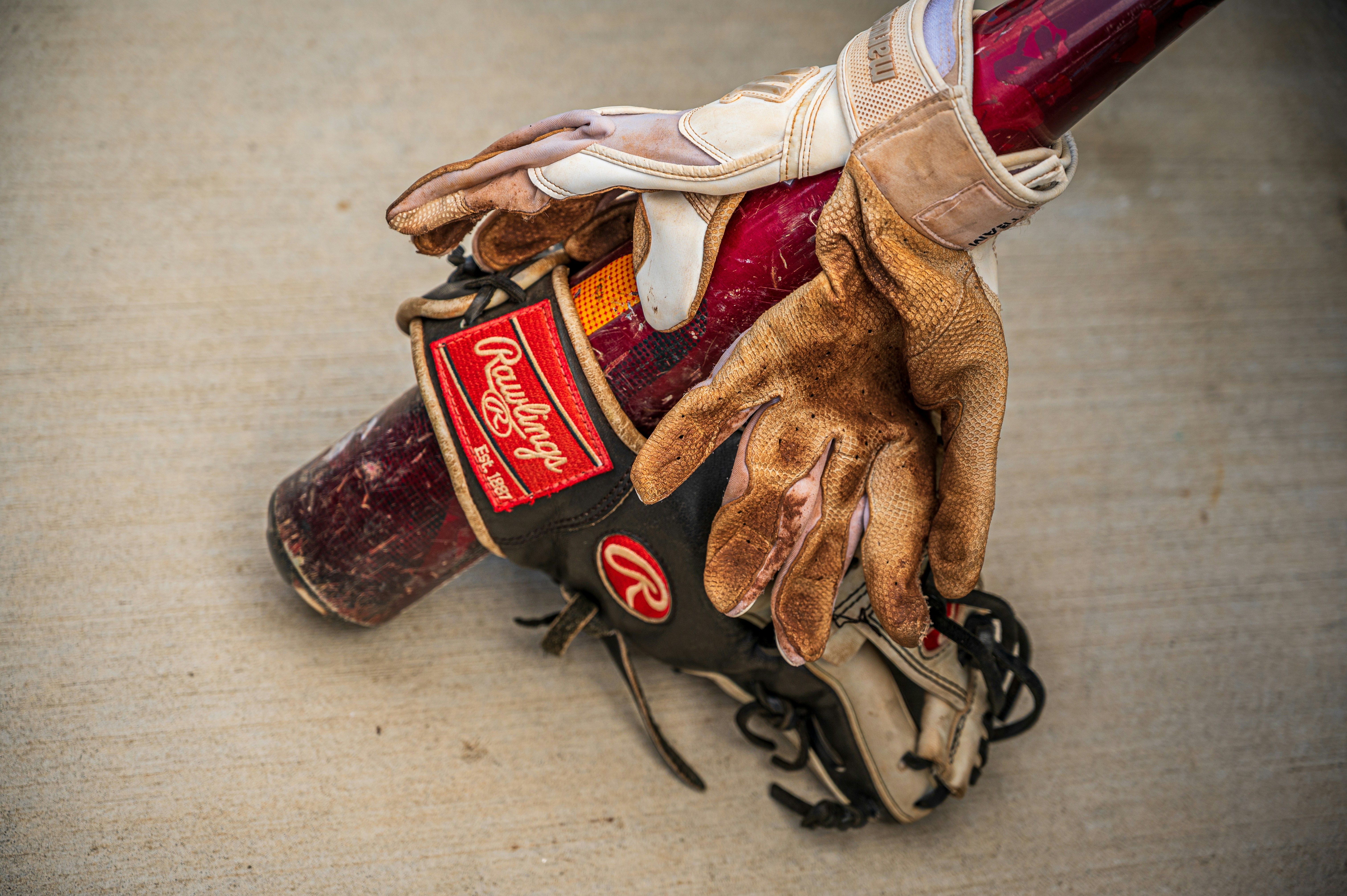 a baseball glove and glove on top of a baseball bat