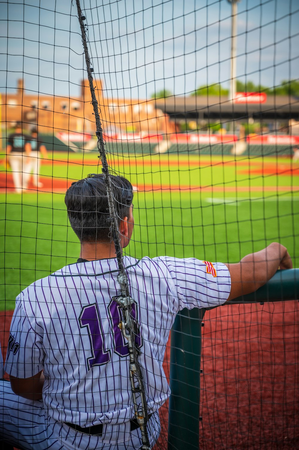 a baseball player sitting in the dugout at a baseball game